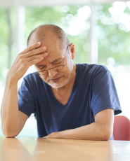 Man suffering from allergies rubbing his head with his hand