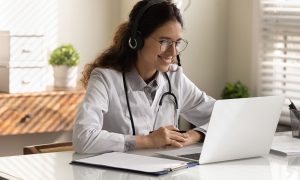 Doctor learning about allergy symptoms online using a laptop computer