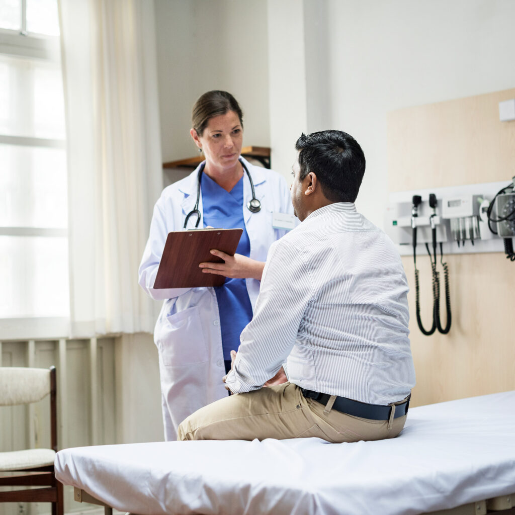 Doctor consulting with a patient in a medical examination room.