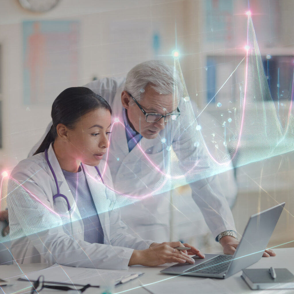 Doctors analyzing symptom tracking data on a laptop in a medical office.