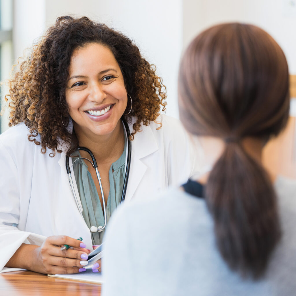 Friendly doctor smiling while consulting with a patient.